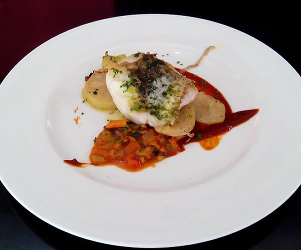 Plato de pescado con salsa y base de patata